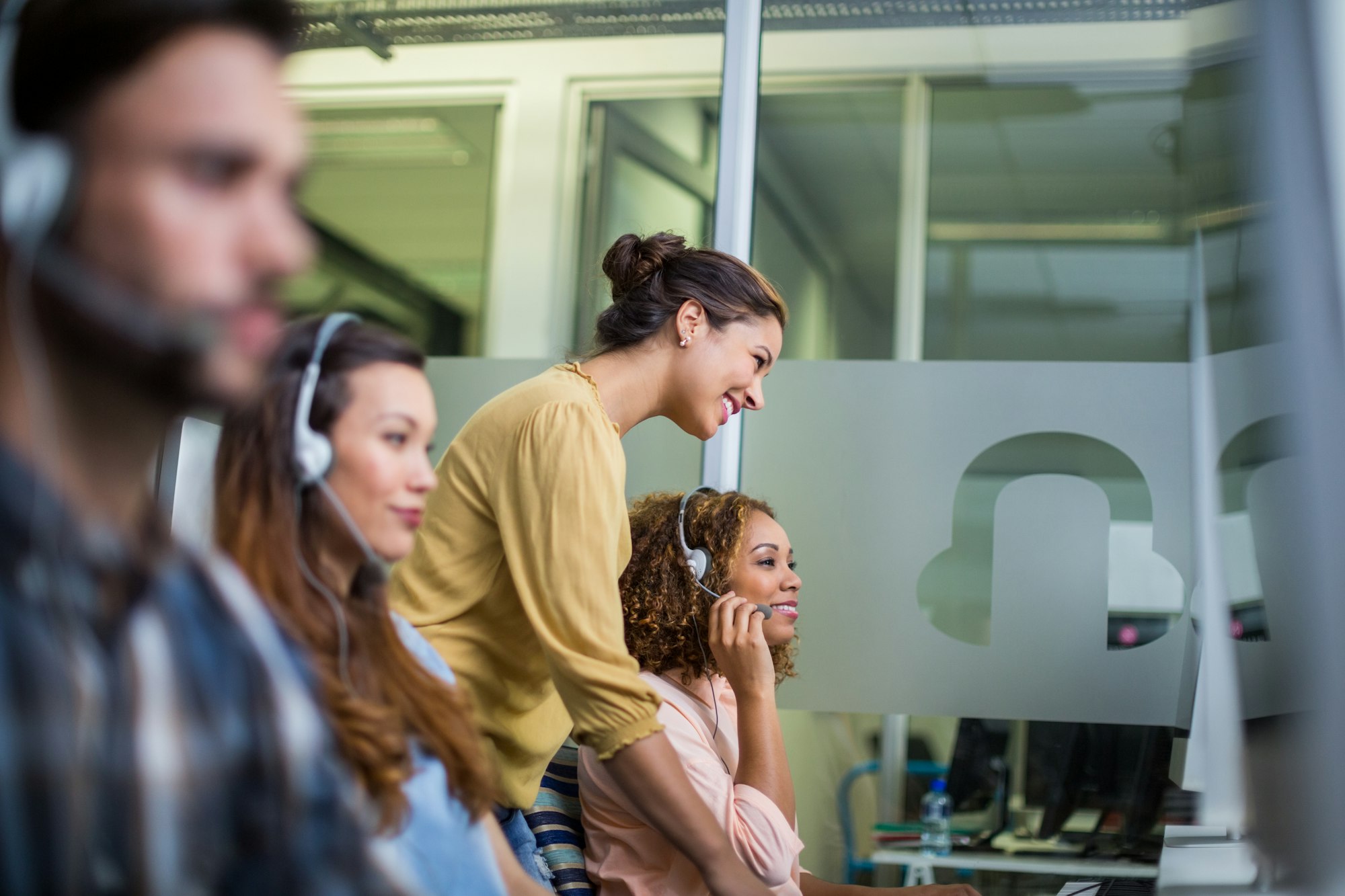 Female customer service executive interacting with her colleague at desk